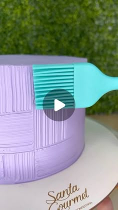 a purple cake with a blue spatula sitting on top of it