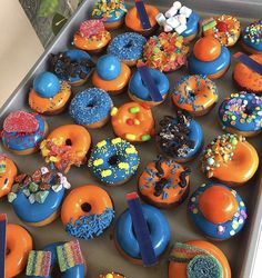 there are many different donuts in the box on the table and one is blue