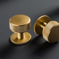 two gold knobs on a black surface with one closed and the other closed,