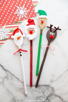 three christmas themed spoons sitting on top of a marble counter