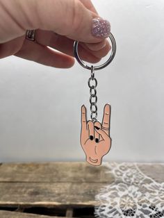 a person holding onto a keychain with a hand drawn on it