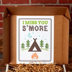 a cardboard box that says i miss you s'more with a campfire in it