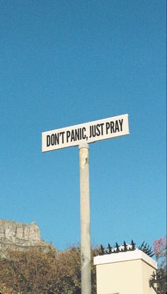 a street sign that says don't panic, just pray