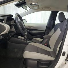 the interior of a car with grey and white seats