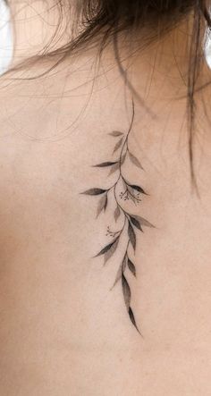 the back of a woman's neck with leaves on it