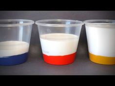 three plastic cups with different colored liquids in them