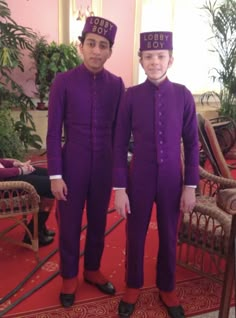 two young men in purple suits standing next to each other