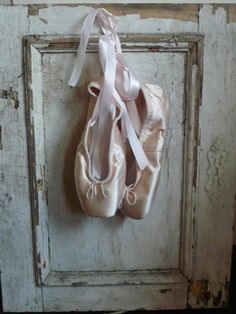 a pair of ballet shoes hanging on a door