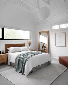 a bedroom with white walls and carpeted flooring, along with a large bed