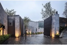 an outdoor courtyard is lit up at night with lights shining on the walls and doors