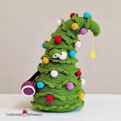 a crocheted christmas tree with decorations on it and a handbag hanging from the top