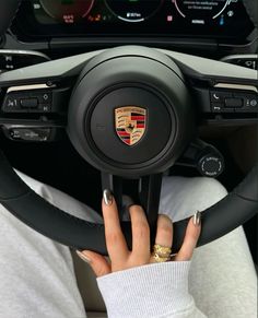 a woman is holding the steering wheel of a car with her hands on the steering wheel