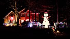 a house with christmas lights on it and a snowman in the front yard