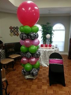 the balloon column is decorated with pink, green and white balloons in zebra print colors