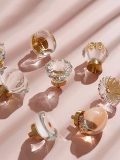 an assortment of glass knobs on a pink surface