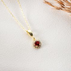 Elegant Gold Ruby Necklace A symbol of passion and vitality, our dainty ruby necklace is more than just an accessory--it's a statement. Crafted with attention to detail, the luminescent ruby pendant set in gold brings forth a touch of elegance and sophistication. Features: Genuine Ruby Gem: Handpicked for its radiant hue, our ruby pendant showcases the deep allure of this July birthstone. Gold Chain: Paired with a high-quality gold chain, the ruby pendant rests delicately, making it perfect for Gift Ruby Necklace With Delicate Chain, Ruby Necklace With Delicate Chain For Gift, Ruby Necklace With Delicate Chain As Gift, Dainty Ruby Necklace For Gift, Dainty Ruby Necklace As Gift, Dainty Ruby Pendant Necklace, Ruby Round Pendant Necklace For Gifts, Ruby Pendant Set, Gold Ruby Necklace