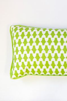 a green and white pillow sitting on top of a bed