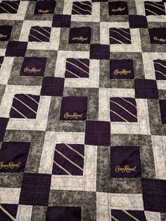 a quilted blanket with ties on it that is purple and grey, in the shape of squares