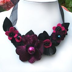 a purple and black flower necklace on a mannequin