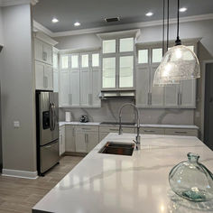 a kitchen with white cabinets and stainless steel appliances