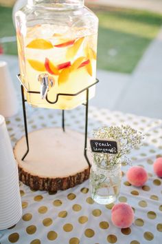 a table topped with a jar filled with liquid and goldfish in it's mouth