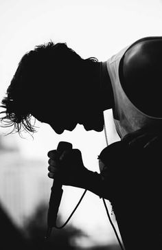 a man holding a hair dryer in his right hand and looking down at it