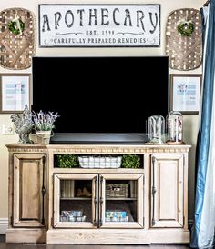 an old tv stand is decorated with wreaths and other decorations