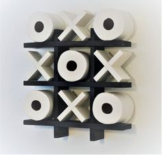 several rolls of toilet paper are arranged on a wall mounted rack in the shape of xoxo