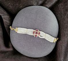 Add a touch of sophistication to your jewelry collection with this exquisite 18k gold bracelet. Featuring a stunning beaded flower design adorned with sparkling diamonds and vibrant rubies, this piece is a true work of art. The delicate pearls add an elegant finishing touch, making it perfect for special occasions or as a thoughtful gift. Each bracelet is handcrafted with meticulous attention to detail, ensuring a unique and high-quality accessory that you'll cherish for years to come. Materials: 18k gold, diamonds, rubies, pearls Design: Beaded flower with diamond and ruby accents Craftsmanship: Handmade with care and precision Occasion: Ideal for weddings, anniversaries, or as a luxurious gift Care Instructions: Store in a dry, cool place and clean with a soft cloth Make a statement with Yellow Gold Bracelets With Round Beads For Weddings, White Gold Bracelet With Round Beads For Wedding, White Temple Jewelry Bracelets, Gold Arm Band, 18k Gold Bracelet, Gold Armband, Ruby Beads, Wide Bracelet, Pearl Design