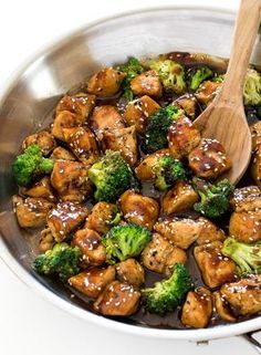 chicken and broccoli stir fry in a pan with a wooden spoon