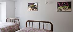 two beds in a bedroom with posters on the wall