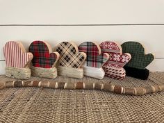 five wooden mittens lined up in a row on top of a woven table cloth