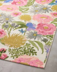 an area rug with flowers and leaves on the floor in pink, green, blue, yellow