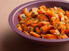 a purple bowl filled with chopped carrots on top of a table