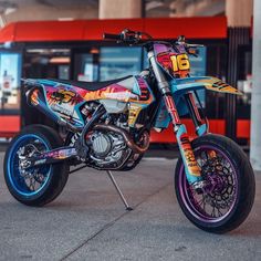 a colorful dirt bike parked in front of a building