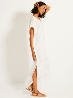 Simple and elegant, the Abira collection features a textured solid and sheer weaving highlighted by delicate shimmering silver dots on a bright white background.This classic caftan features a plunge neckline, short cap sleeves, hand-twisted fringe hem making it the perfect beach cover-up. Hand-woven in Ethiopia, this silhouette is made of soft hand-spun cotton for a light and comfortable feel. GIVING BACK | 5% of all purchases will be donated to the lemlem Foundation. Bright White Background, Caftan Dress, Plunge Neckline, Fall Accessories, Dress Robes, Giving Back, Soft Hand, Hand Spinning, Swimwear Accessories