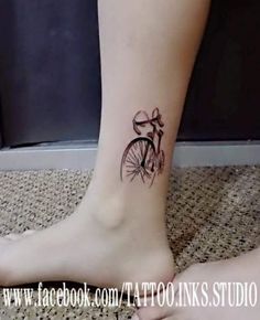 a woman's foot with a bicycle tattoo on it