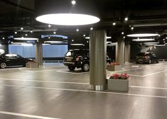 an empty parking garage with several cars parked in the space between two columns and round lights