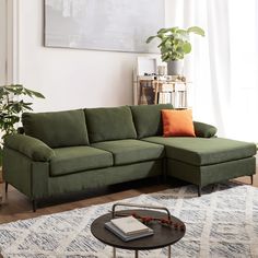 a living room with a sectional couch and coffee table in it, next to a painting on the wall