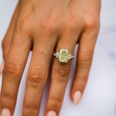 a woman's hand with a yellow diamond ring