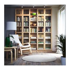 a living room filled with lots of furniture and bookshelves next to a window