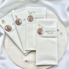 five pieces of white paper on top of a plate with two penny coins in the middle