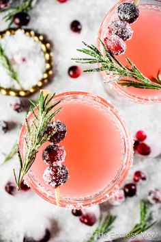 two glasses filled with cranberry punch and garnished with rosemary sprigs