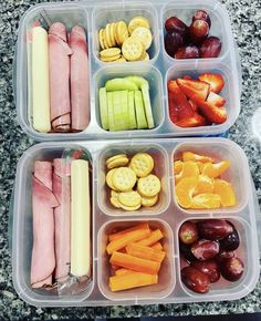 two plastic containers filled with food on top of a granite countertop next to fruit and crackers