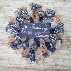 a wreath that says jesus is the reason for the season with blue and brown bows