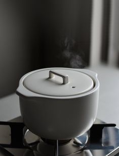 a white object sitting on top of a metal burner with steam coming out of it