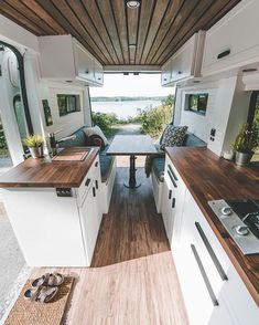 the interior of a camper with wood flooring and white cabinets is shown in this photo