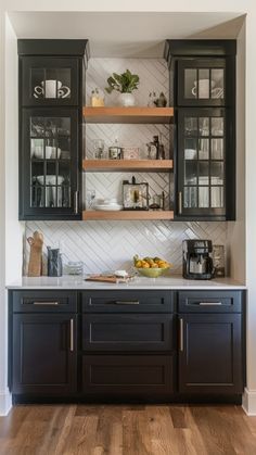 a kitchen with black cabinets and white counter tops, wood flooring and open shelves