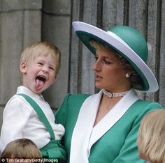 the young boy is wearing a green and white hat while his mother looks at him