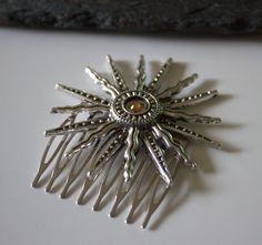 Celestial Aztec Sun hair comb.  The hair comb has a beautiful sun with a central golden crystal.  The hair comb measures 68mm in total height.  The teeth of the comb measure 40mm in width and the sun has a diameter of 60mm.  The sun is attached to the comb using strong jewellery glue. Perfect for that special occasion or for everyday use. Gift wrapped in tissue paper and presented in an organza pouch. Celestial Hair, Sun Hair, Aztec Sun, Golden Crystal, Moon Wedding, Caramel Highlights, Organza Pouch, Flower Hair Comb, Bridal Comb